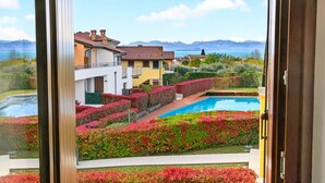 A residential area with a swimming pool, manicured gardens, and a view of mountains. - Regarda - Miralago 2, bike apartment with pool, lake view, garage (Lazise)