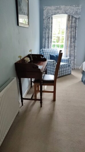 A room with a wooden desk, a chair, a radiator, a window with curtains, and a blue wall. - Stunning Hall Cottage, near York and Leeds (Wighill)