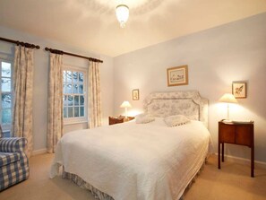 A bedroom with a large bed, two bedside tables with lamps, a chair, and a window with curtains. - Stunning Hall Cottage, near York and Leeds (Wighill)