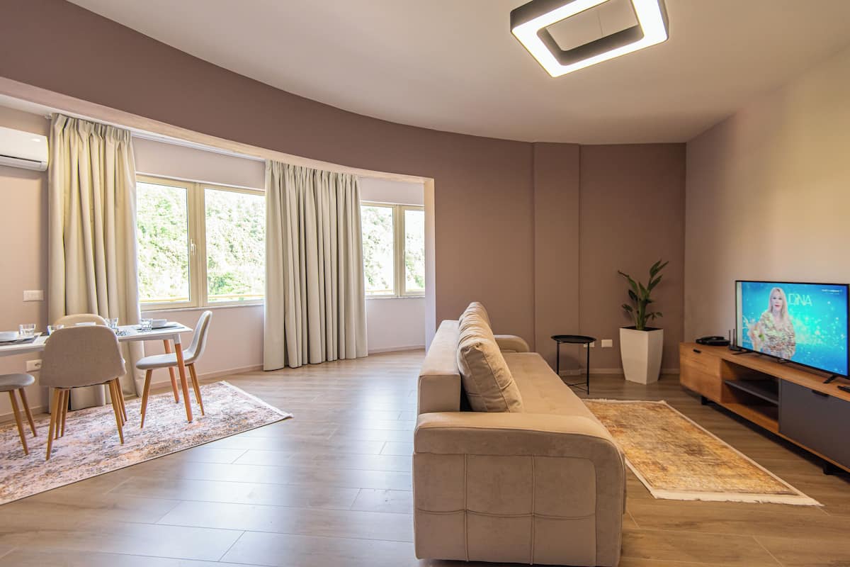 Superior appartement | Woonruimte | Een 32-inch flatscreentelevisie met kabelzenders en Netflix