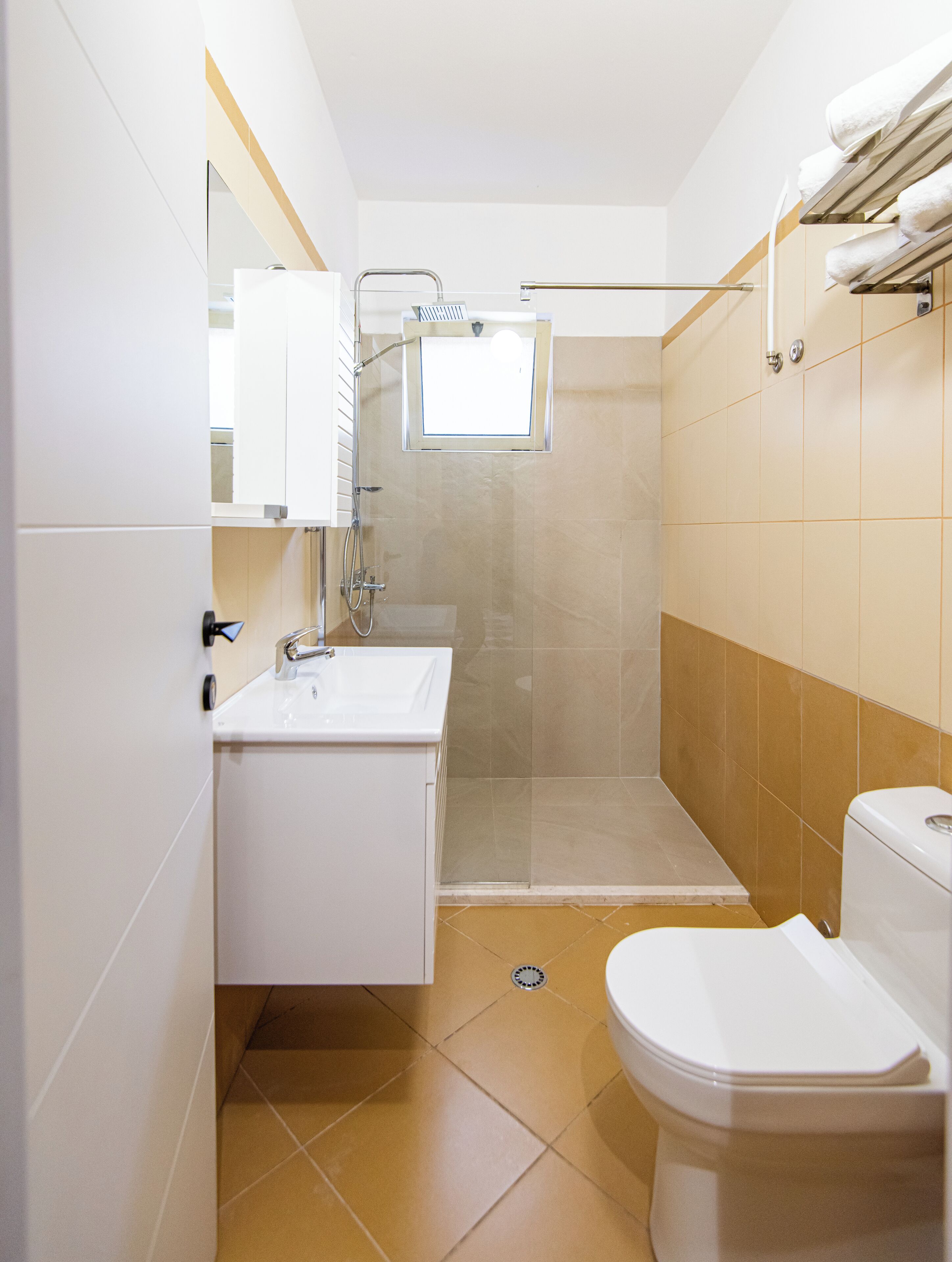 A compact bathroom with a shower, toilet, and sink.