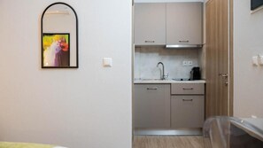 Frigorífico pequeño, placa de cocina y máquina de café espresso