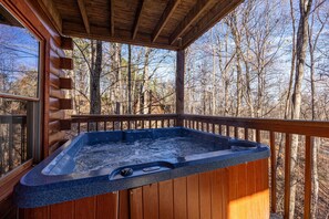 Relax in a hot tub on a deck overlooking the forest.