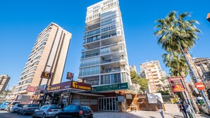 A multi-story building with a modern design, featuring balconies and large windows. - Niza 2-A Apartment Levante Beach (Benidorm)