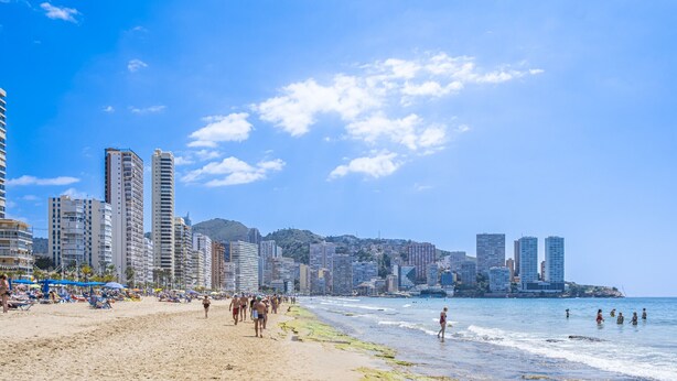 A beach with people walking and swimming, surrounded by tall buildings. - Niza 2-A Apartment Levante Beach (Benidorm)