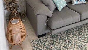 A grey sofa with floral cushions, a woven side table, and two framed zebra prints on the wall. - Villa Marina, Relax, Piscina Privada, Barbacoa, Wifi (Son Vitamina)