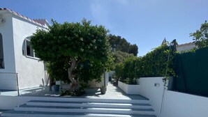 A concrete pathway leading to a white building with a tree in the center. - Villa Marina, Relax, Piscina Privada, Barbacoa, Wifi (Son Vitamina)