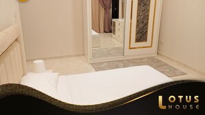 Ein Hotelzimmer mit einem Bett, einem Kleiderschrank, einem Spiegel und einer Tür zu einem Badezimmer.