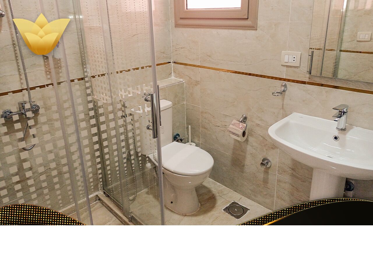 Ein Badezimmer mit Duschkabine, Toilette und Waschbecken.