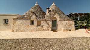 Ein Steinhaus mit zwei Kegeldächern und einer kleinen Tür.