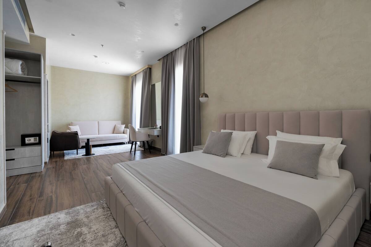 Una habitación de hotel moderna con una cama grande, un escritorio y un armario.