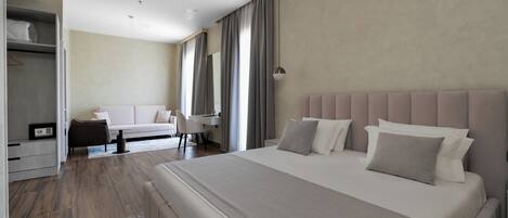 Una habitación de hotel moderna con una cama grande, un escritorio y un armario.