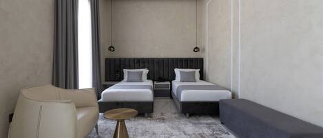 Une chambre d’hôtel moderne avec deux lits, un canapé, une table basse et une grande fenêtre avec des rideaux.