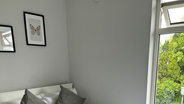 A neatly made bed with a heart-shaped towel arrangement, grey pillows, and a grey throw blanket. - Modern and Spacious No. 6 - sleeps 6 - free parking (Galway)