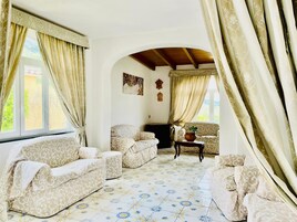 Una sala acogedora con sofás estampados, una mesa de centro y una chimenea.