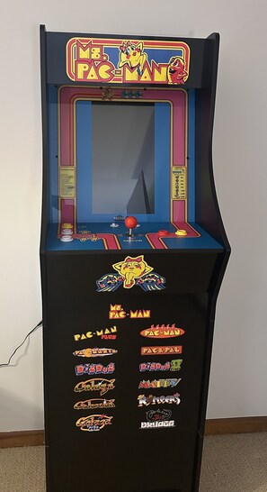 Uma máquina de jogos antiga com tela grande, joystick e moedeiro.