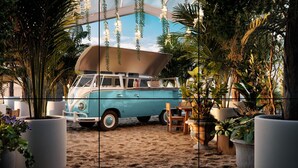A vintage blue van parked on a sandy surface, surrounded by potted plants and a hanging light fixture. - Cozy studio with AC and WiFi in enchanting San José (San José)