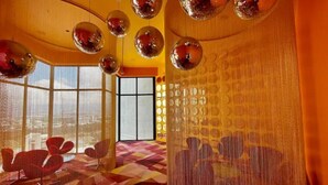 A room with a checkered floor, red chairs, and a large window with a view. - Cozy studio with AC and WiFi in enchanting San José (San José)