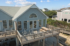 A two-story house with a deck and outdoor seating area.