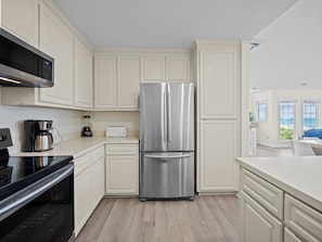 A modern kitchen with a stainless steel refrigerator, a microwave, and a coffee maker.