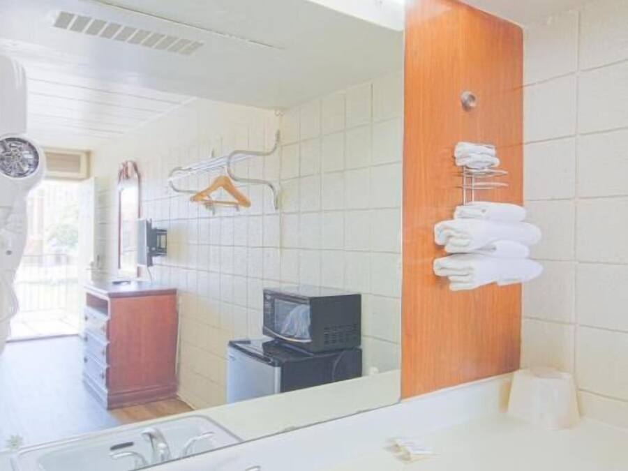 Un baño moderno con un espejo grande, un lavabo y un perchero para toallas.
