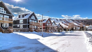 A snow-covered residential street with houses featuring balconies and a clear sky. - Brand New 7 bdrm Luxury Cottage with Private Beach Access, BBQ,7.5 baths, Hot Tub, Ping Pong Table (The Blue Mountains)