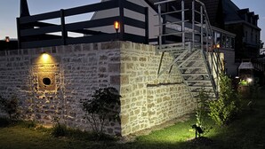 Un bâtiment en pierre doté d’un escalier en bois et d’une rambarde en métal.