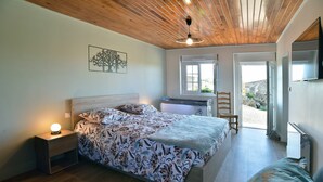 Une chambre à coucher avec un lit, une table de chevet et une fenêtre.
