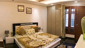 A bedroom with a bed, nightstand, chair, and a wardrobe. - The place is very much pleasing , adorable and comfortable . Also amazing decor  (Delhi)