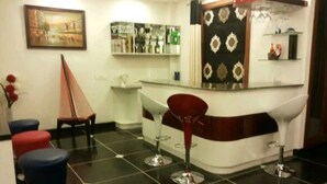 A bar area with a counter, stools, and a decorative wall. - The place is very much pleasing , adorable and comfortable . Also amazing decor  (Delhi)