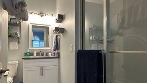 A bathroom with a toilet, sink, and shower area. - Beautiful Condo on Golf Course (Horry County)