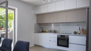A modern kitchen with white cabinets, a marble countertop, and stainless steel appliances. - Villa Oliva Beautiful Magnificent View, Pool, Newly Built, Close to the Beach (Zaton)