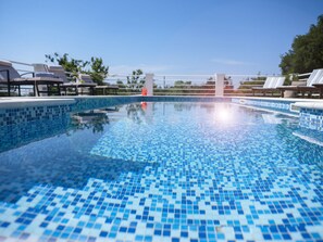 A clear blue pool with tiled edges, surrounded by lounge chairs and umbrellas, indicating a resort setting. - Villa Oliva Beautiful Magnificent View, Pool, Newly Built, Close to the Beach (Zaton)