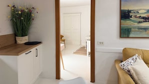 A kitchen with a wooden countertop, a potted plant, and a view into a dining area with a white door. - JOLLI One-Bedroom Apartment (Rovinj)