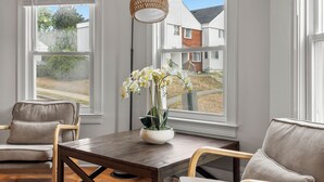 Un coin repas avec une table en bois, deux chaises et un vase de fleurs.