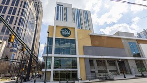 A Whole Foods Market building with a modern glass facade, located in an urban setting with tall buildings nearby. - Royal Retreat (Atlanta)