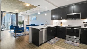A modern kitchen with dark cabinets, stainless steel appliances, and a large island. - Royal Retreat (Atlanta)