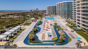 Ein Resort mit mehreren Swimmingpools, einem Parkplatz und Blick auf den Ozean.