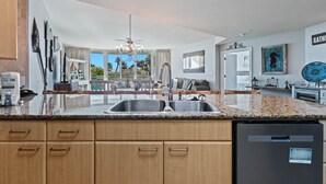 Una cocina moderna con encimeras de granito, armarios de madera y lavavajillas integrado.