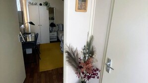 A hallway with a wooden floor, a white door, a small plant, and a framed picture on the wall. - Ninalodge - Cosy, private self-contained apartment (Letterkenny)