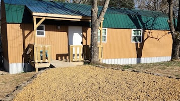 Guests can enjoy a peaceful stay in this cozy retreat with a front porch and bench.