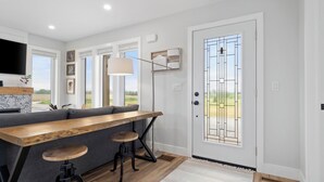 Una cucina moderna con un'isola in legno, sgabelli da bar e una grande finestra.