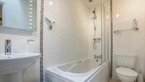 Un baño moderno con bañera, lavabo e inodoro.