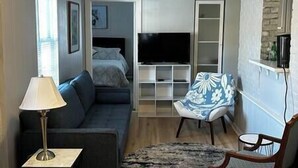 A compact living space with a sofa, a chair, a TV, and a small table. - Walk To Goodspeed Opera House! (East Haddam)
