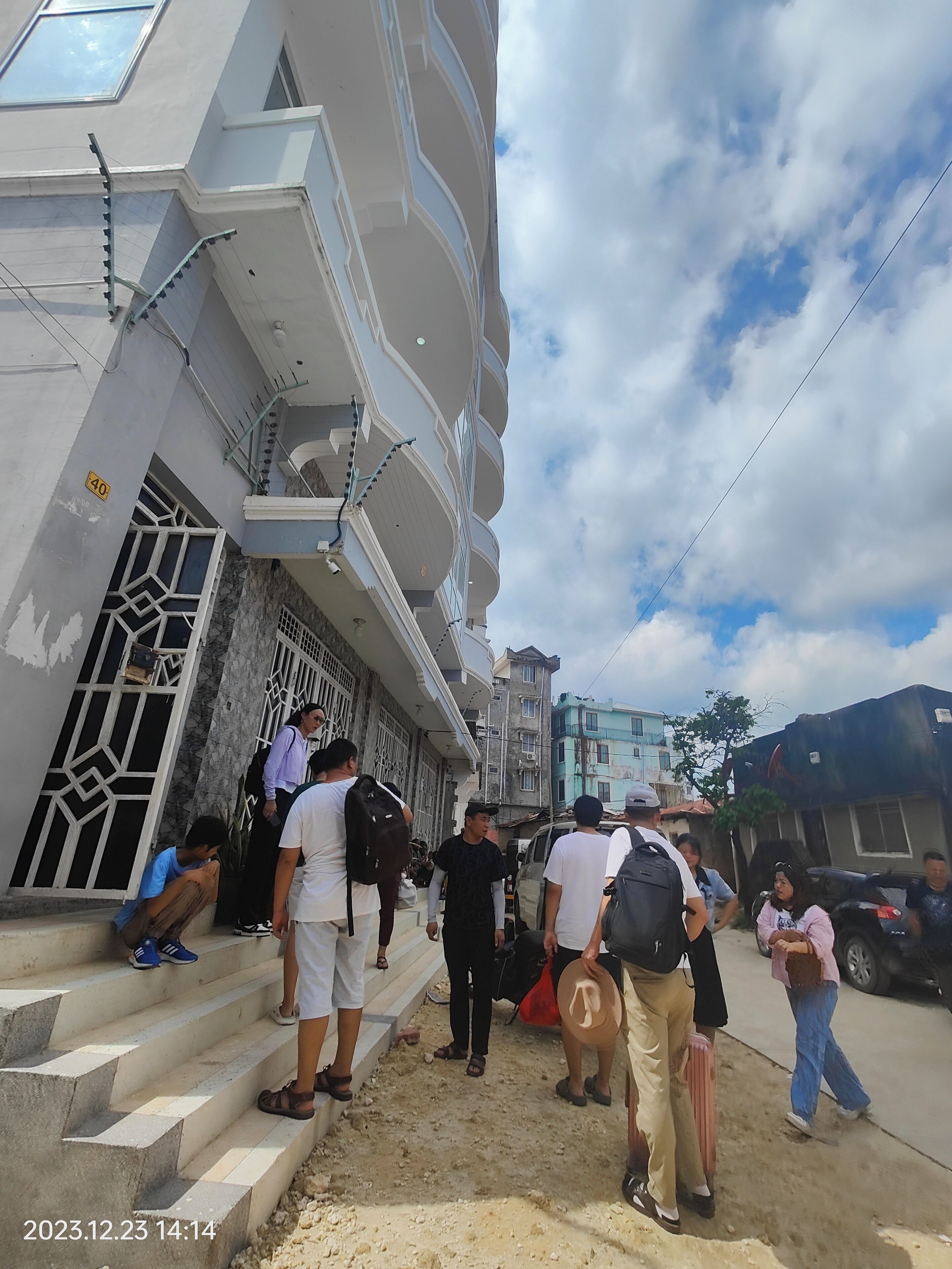 A building with a staircase leading to a landing, surrounded by other buildings.