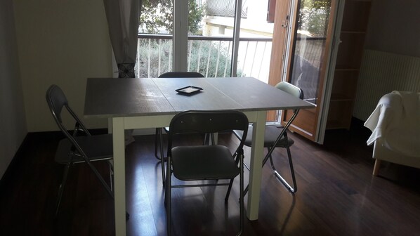 Enjoy meals in this cozy dining area with a table and chairs, overlooking the outdoors through a window.