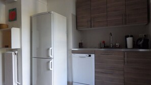 Kitchen features a refrigerator, dishwasher, and sink with faucet.