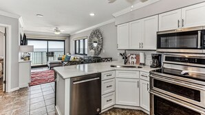 A modern kitchen with white cabinets, stainless steel appliances, and a dishwasher.