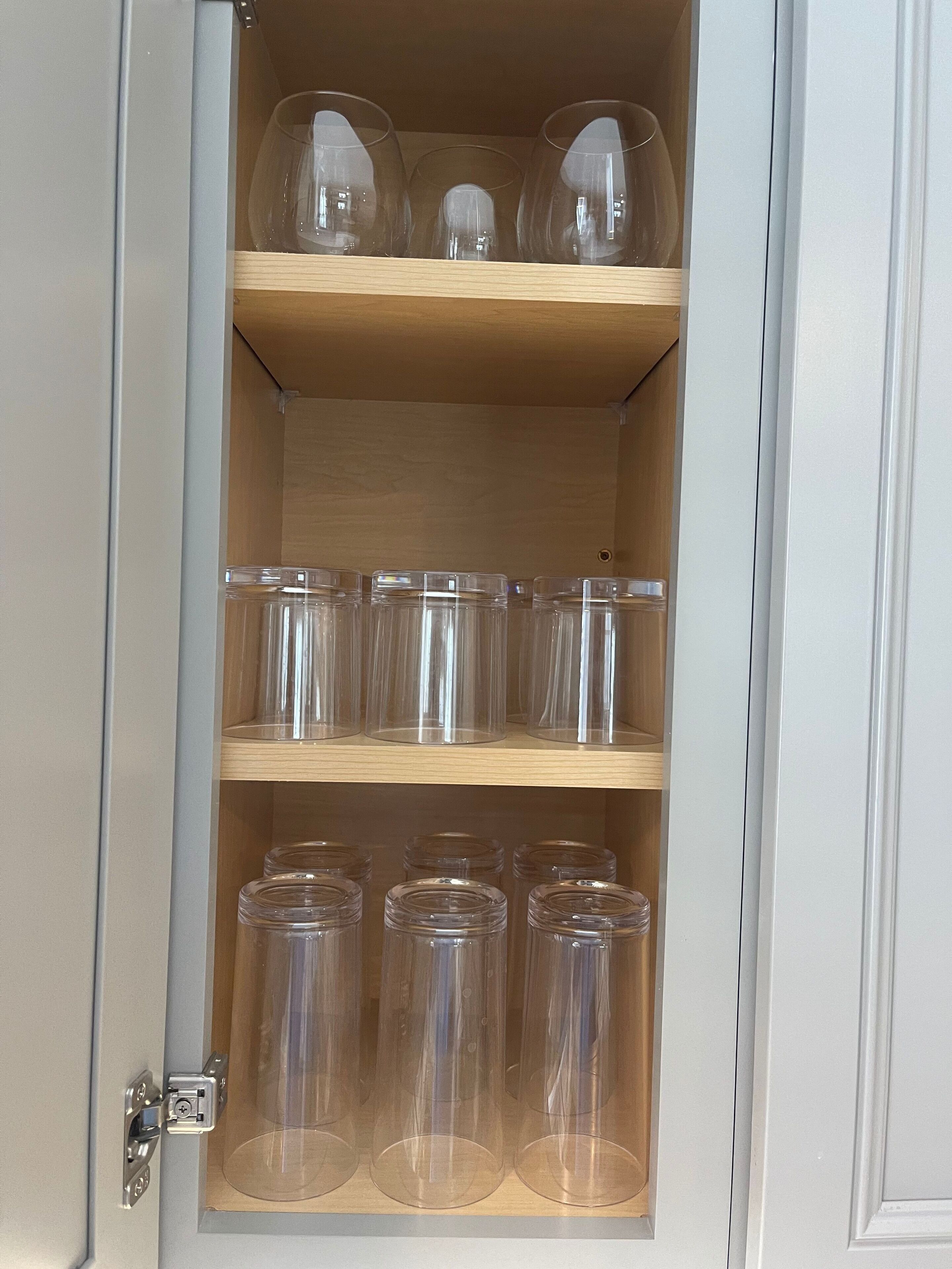 Un meuble avec trois étagères, chacune contenant des récipients en verre transparent.