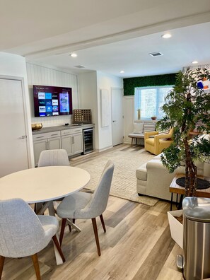 Relax in this stylish living space with a round dining table, oven, and flat-screen TV.